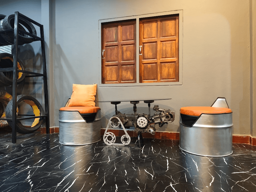 Customer lounge with engine coffee table and oil drum seating at Krabi Moto Rentals