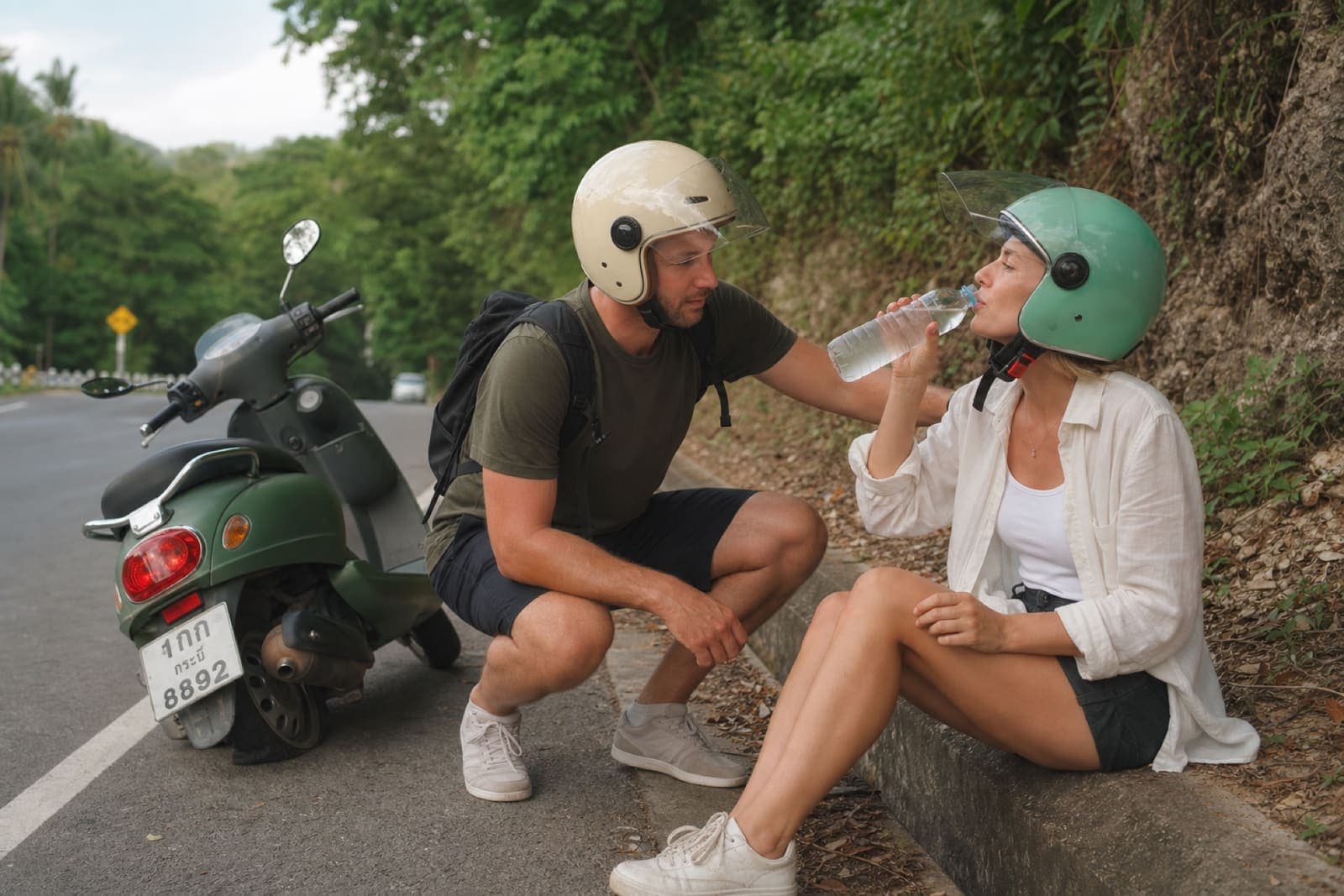 Riders staying calm and drinking water on the roadside after a minor Krabi motorbike accident