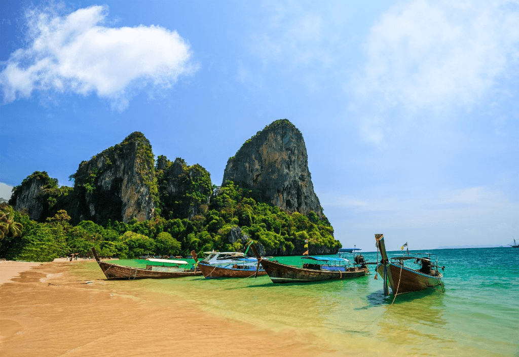 Railay West Beach with long-tail boats and limestone cliffs on the Andaman Sea, Krabi