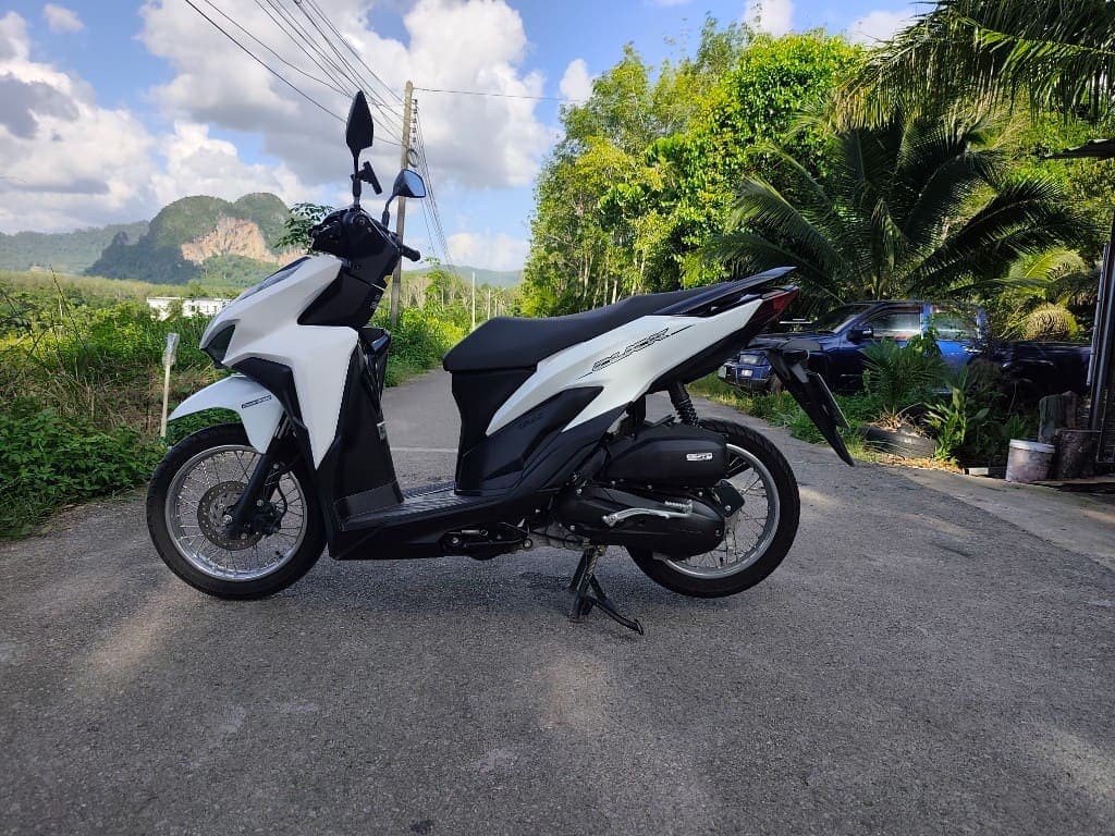 Honda Click 125 side profile on a scenic Krabi road