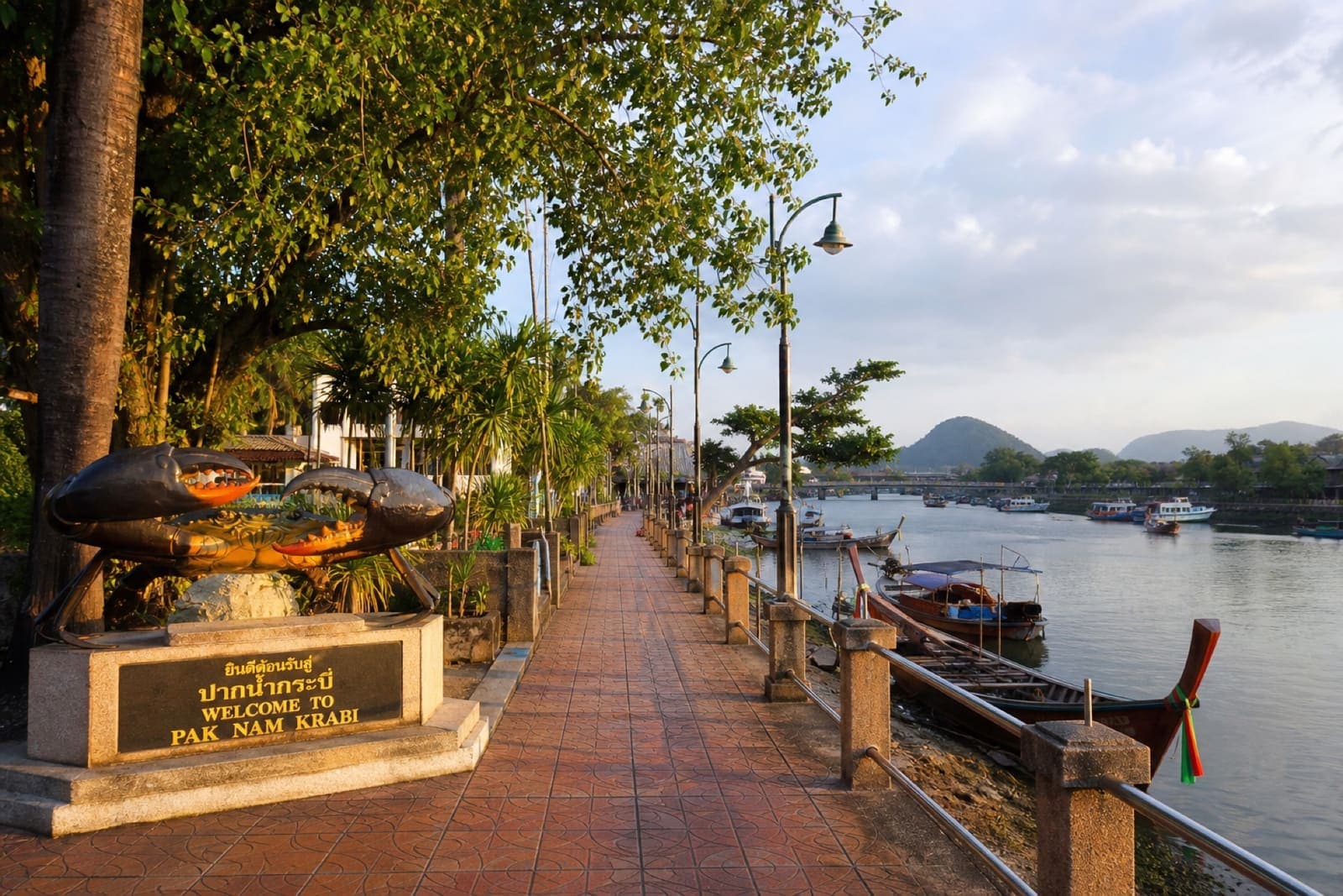 Pak Nam riverside promenade along the Krabi River with long-tail boats