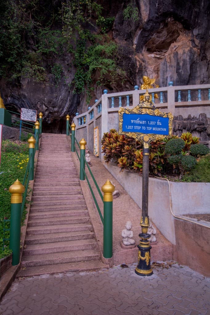 Sign at the base of Tiger Cave Temple staircase showing steps to the mountaintop