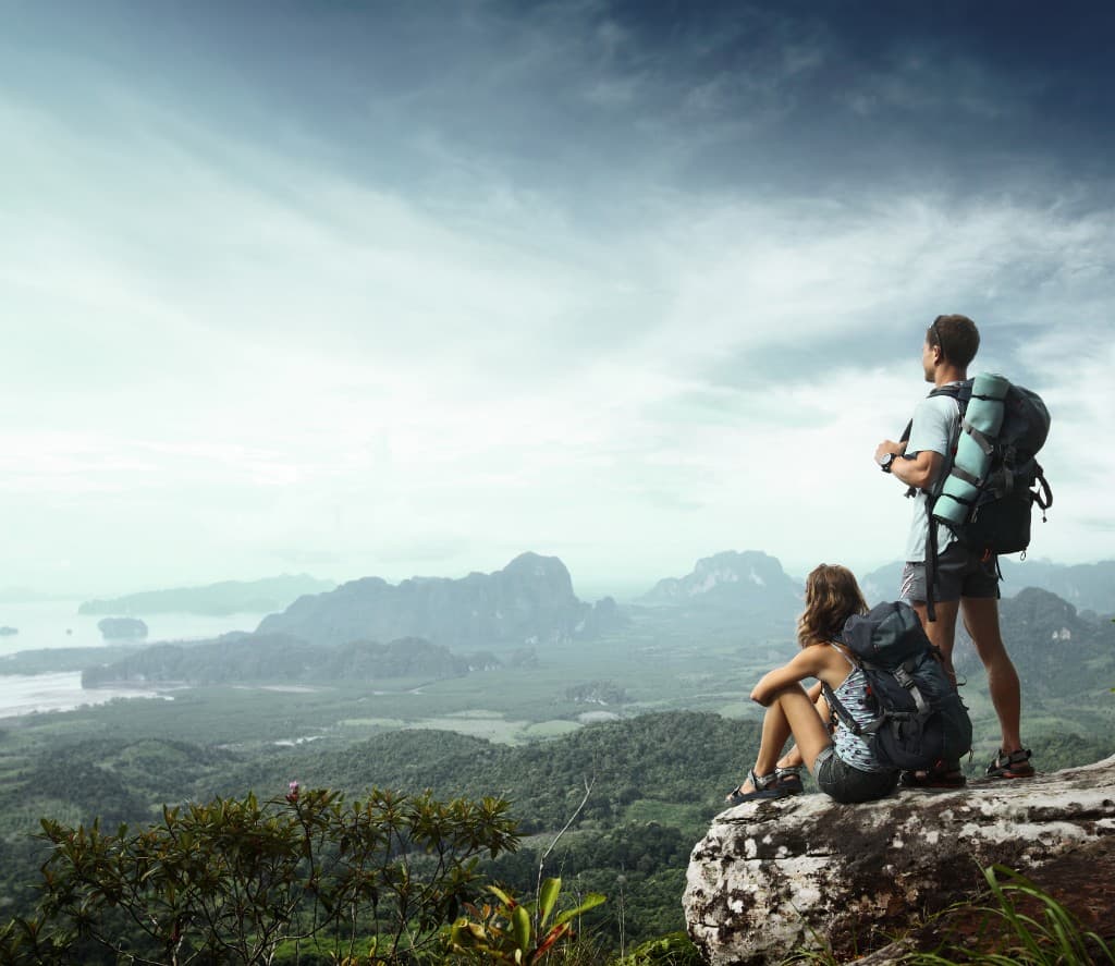 Hikers at a mountaintop viewpoint overlooking Krabi’s limestone landscape and islands