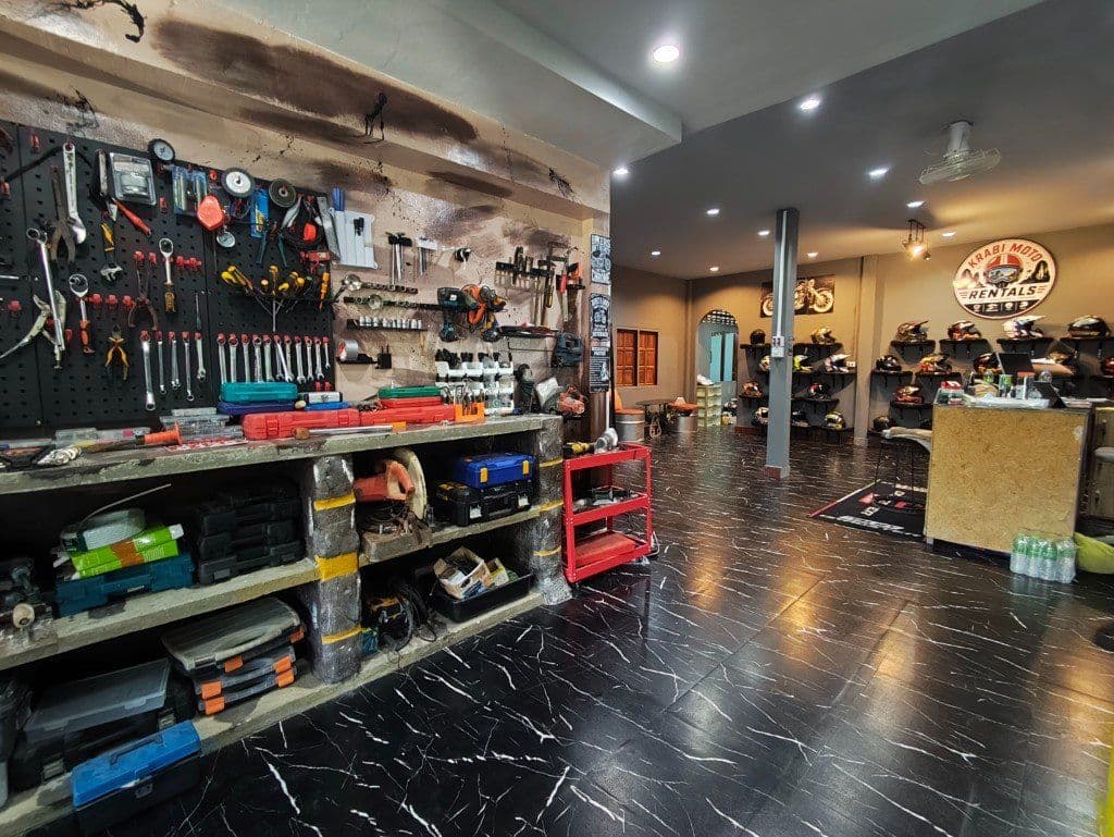 Krabi Moto Rentals shop interior with workshop, helmet wall and front desk