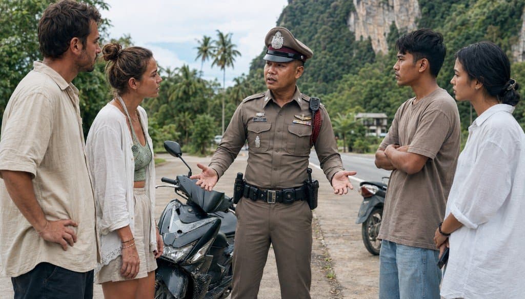 Thai police officer mediating between tourists and locals after a motorbike accident in Krabi