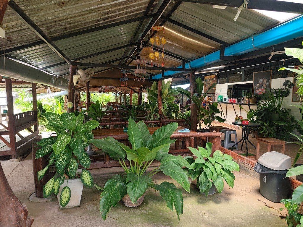 E-san Tai Restaurant — rustic open-air Isan dining with wooden benches and tropical garden seating
