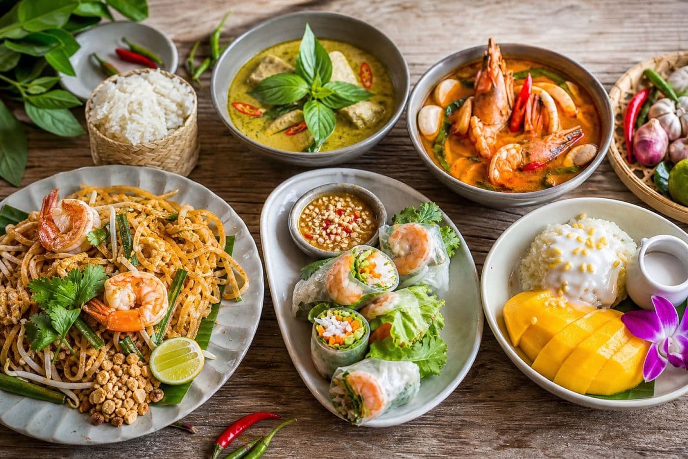Beautiful spread of authentic Thai dishes including pad thai, curry and tom yum