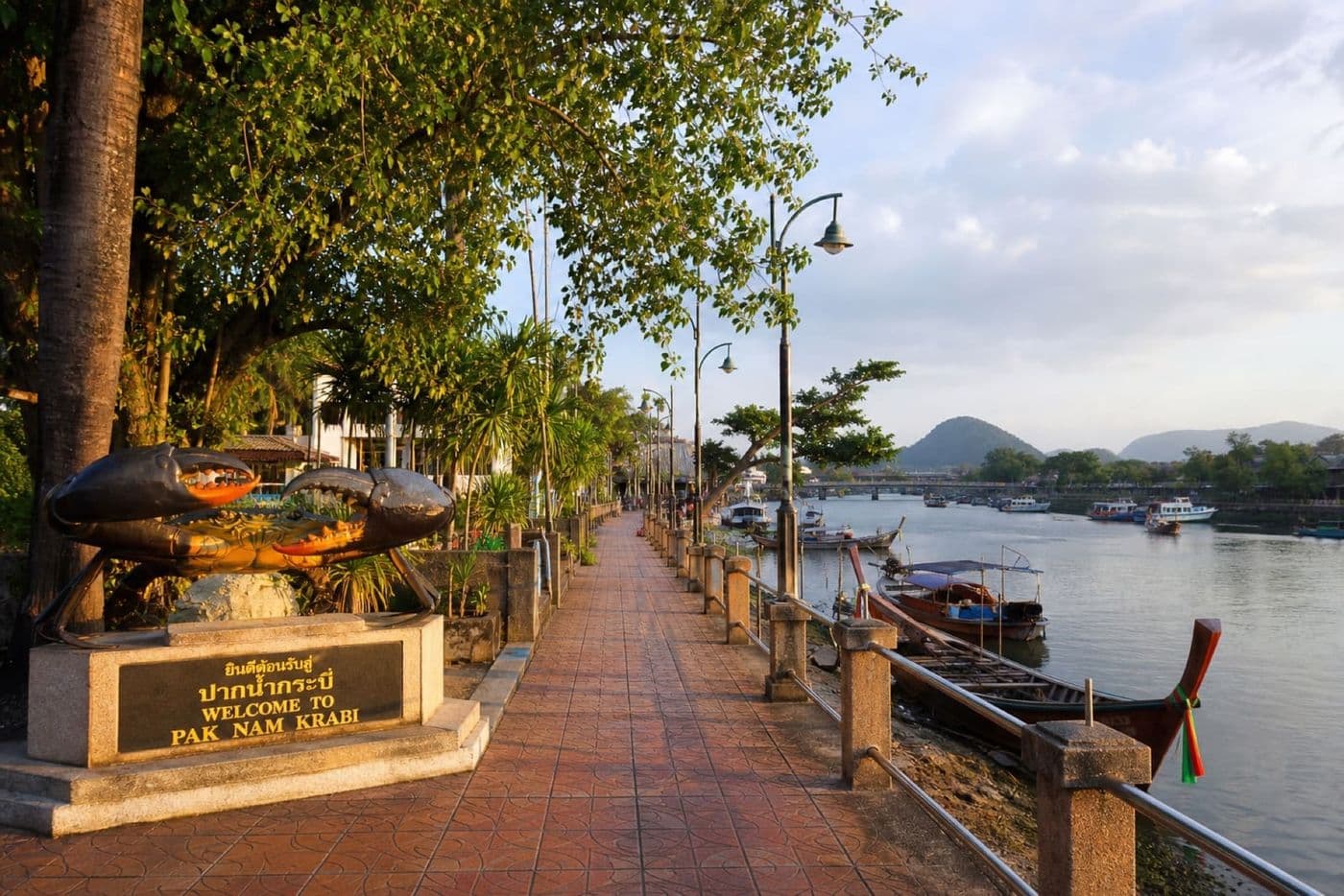 Pak Nam riverside promenade along the Krabi River with long-tail boats