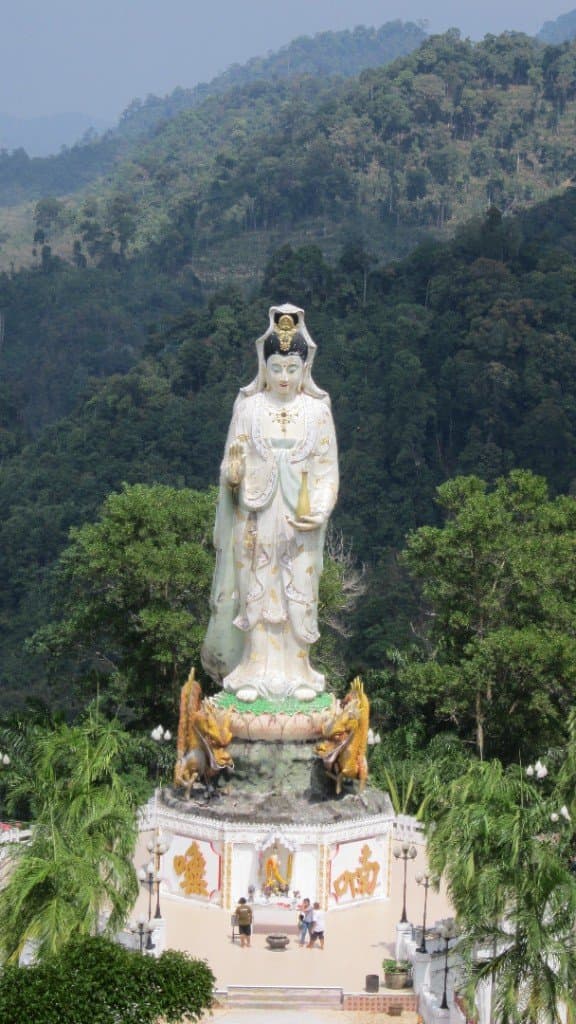 White Guanyin statue at Wat Bang Rieng with forested mountains, Phang Nga