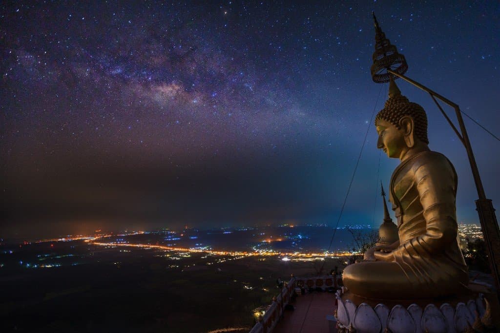 Large golden Buddha statue at Tiger Cave Temple summit overlooking Krabi at night