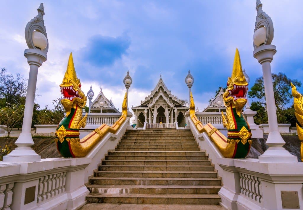 Wat Kaew Korawaram white temple in Krabi Town with golden Naga serpent staircase and blue roof